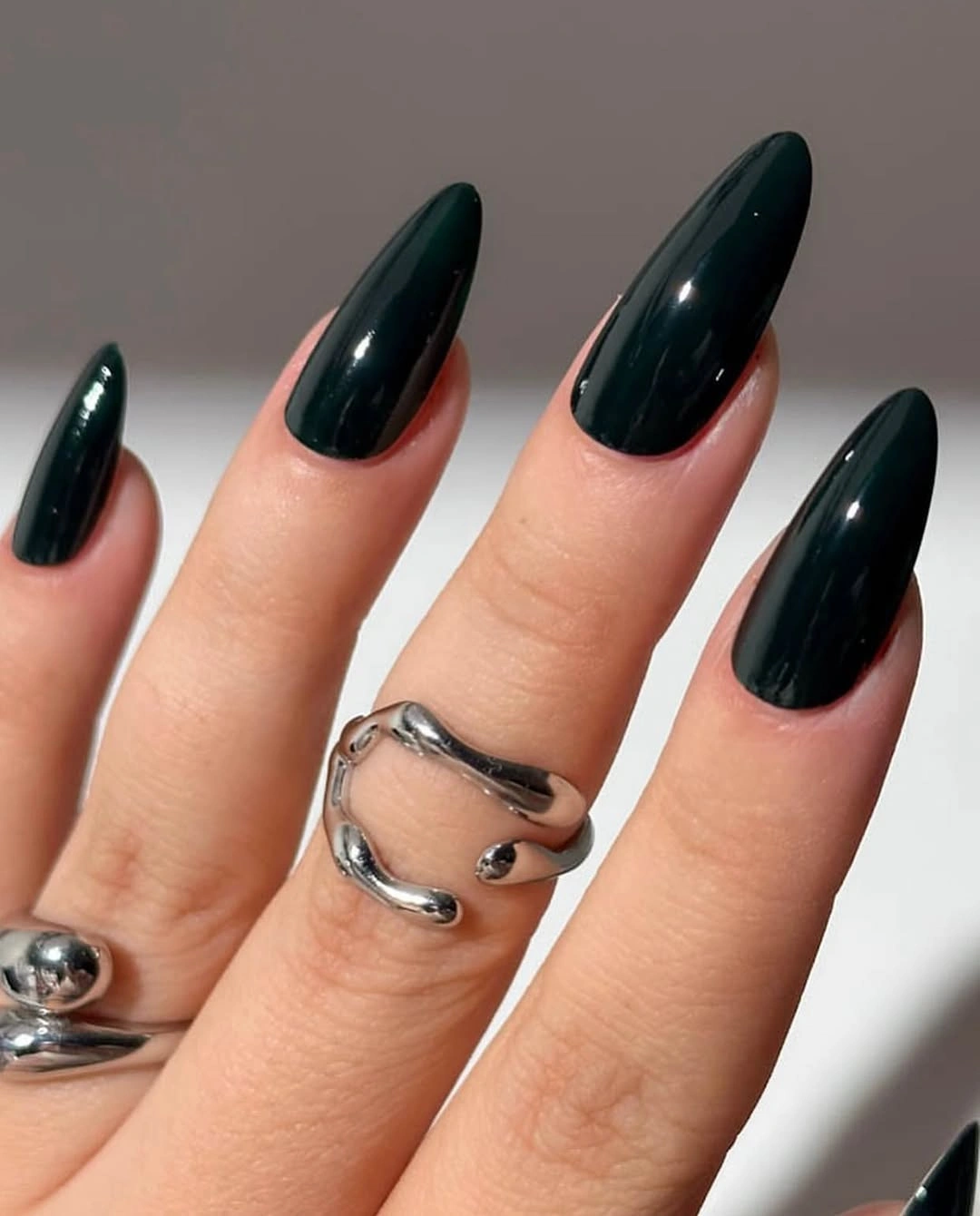 Long almond nails in one deep glossy blue green shade