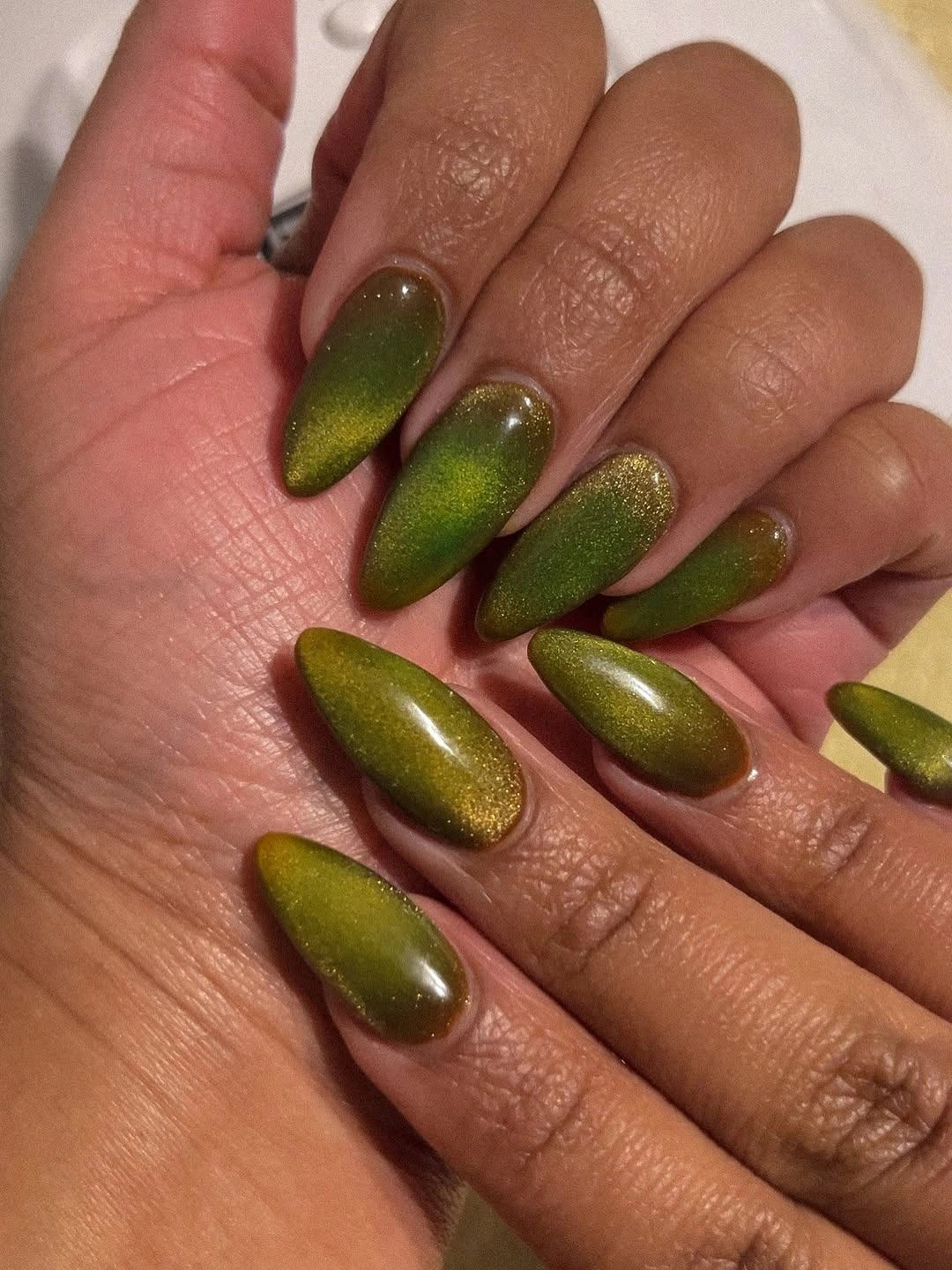 Olive green almond nails with fine gold shimmer