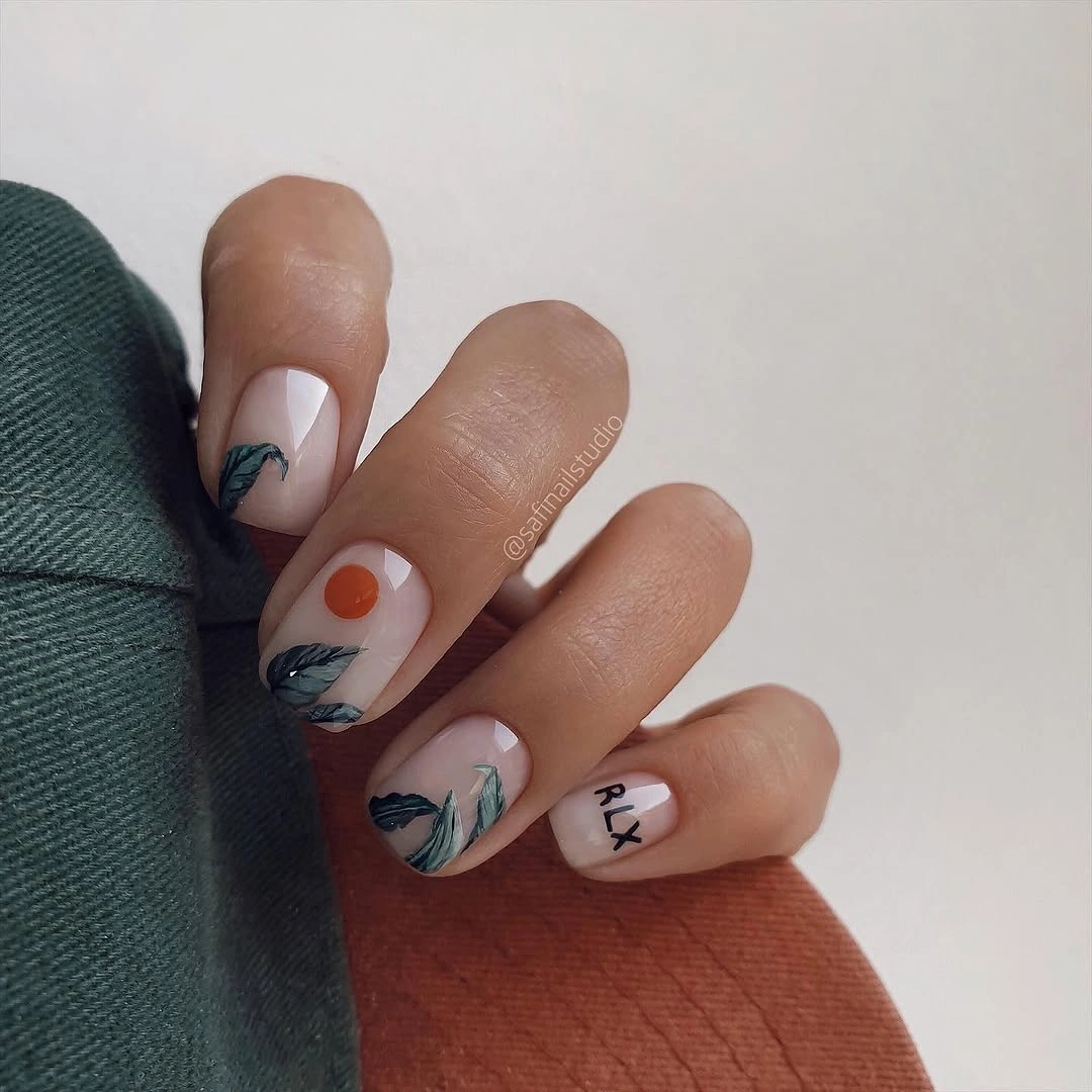 Short nude nails with green leaves and orange dot