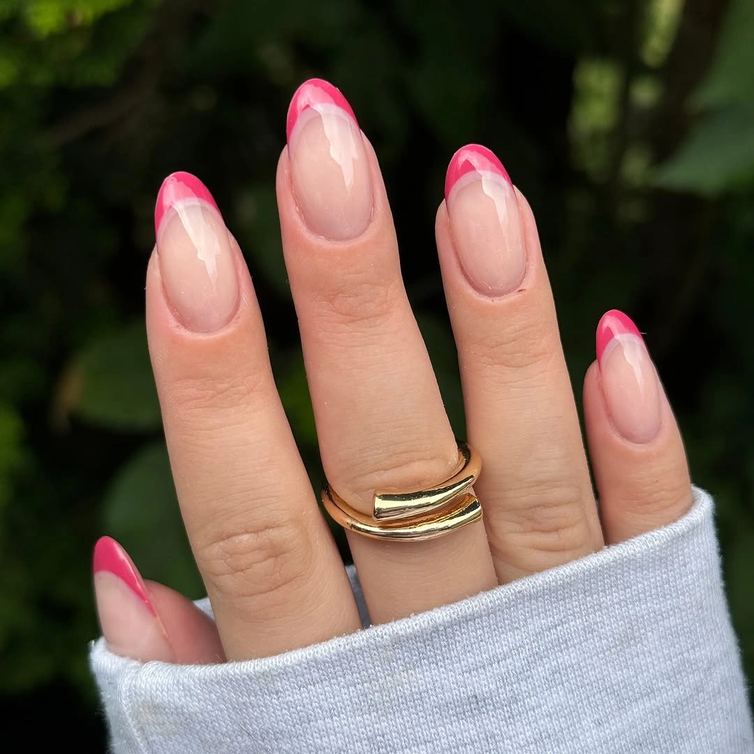 Sheer almond nails with hot pink French tips