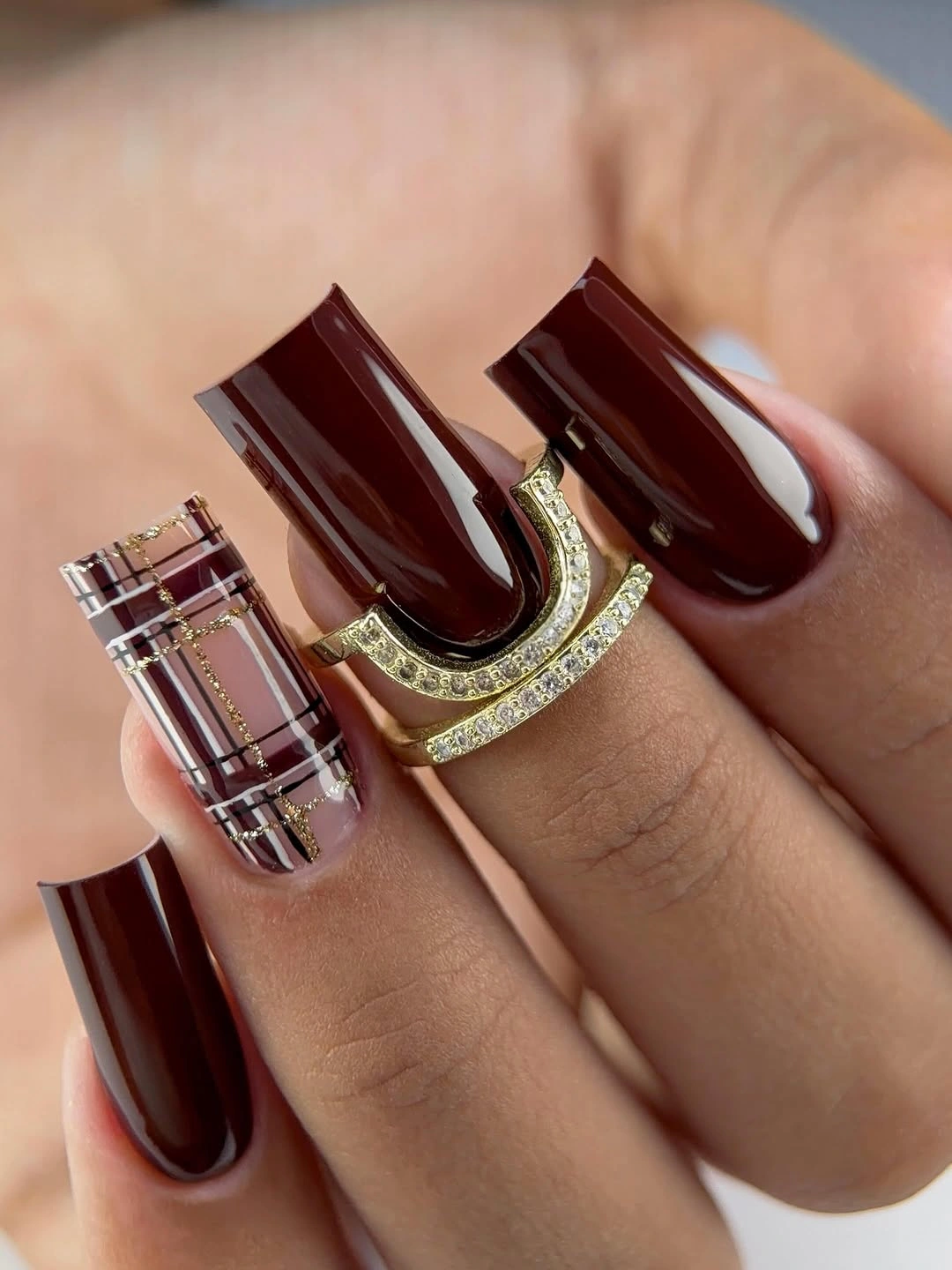 Long burgundy square nails with one plaid accent