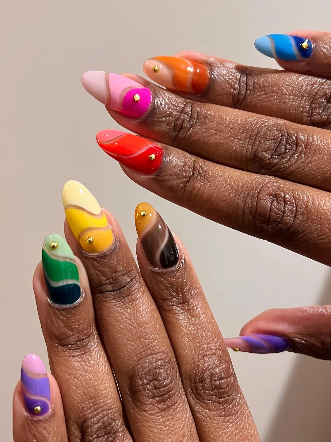 Long pointed nails with bright mixed colors and tiny decorative accents
