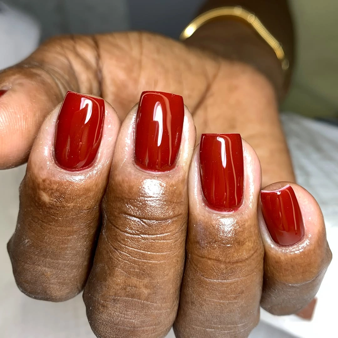 Short square nails in a clean glossy deep red shade