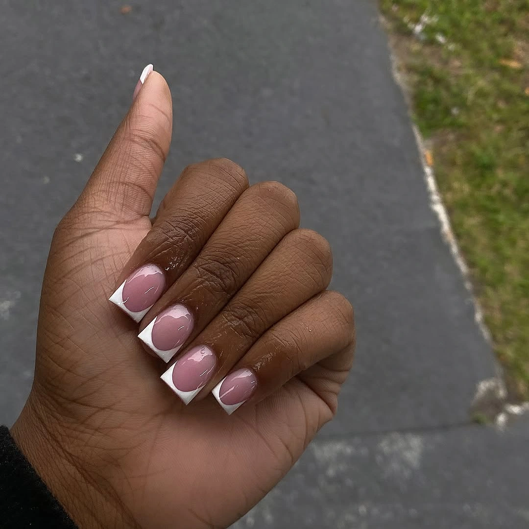 Short rounded nails with pale pink bases and soft white French details