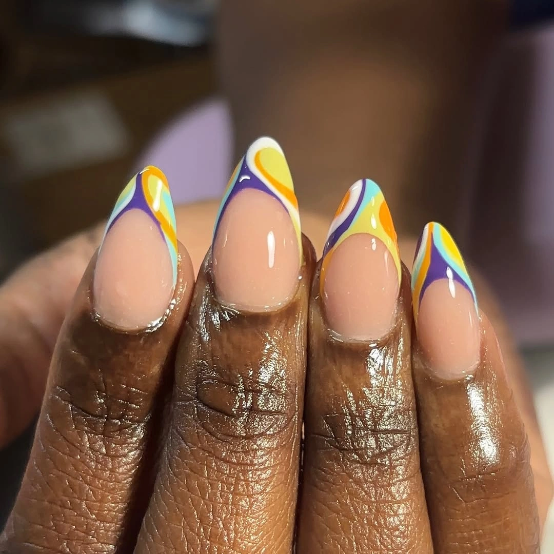 Long almond nude nails with neon yellow blue and violet French swirls