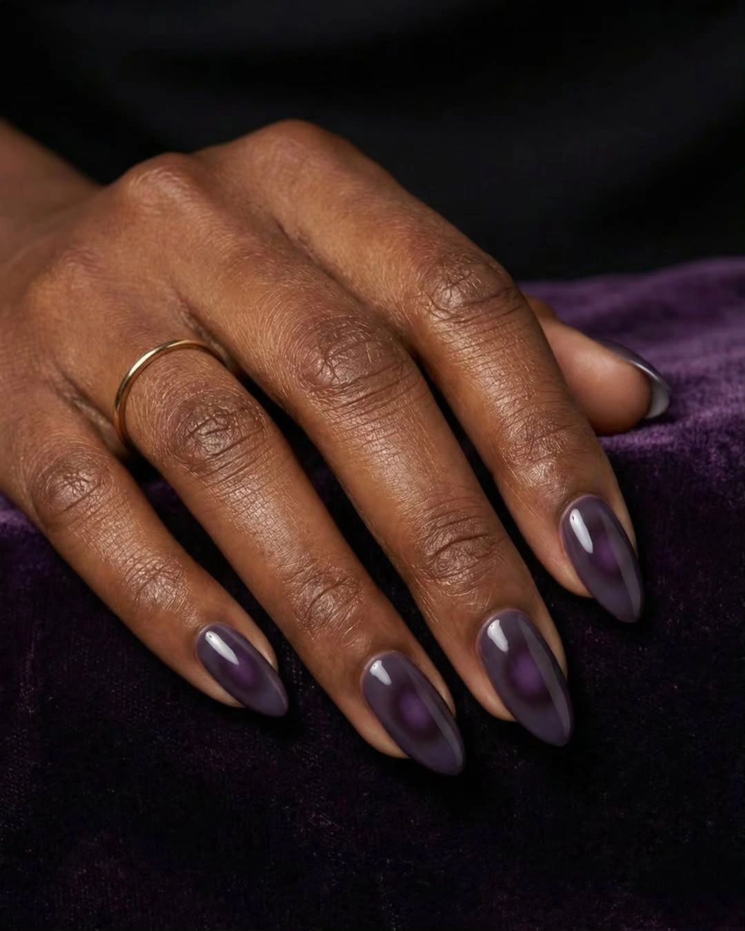 Long almond nails in a deep glossy plum-purple shade