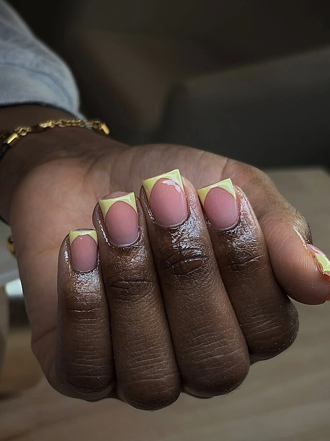 Short rounded-square pink nails with bright lime-green French edges