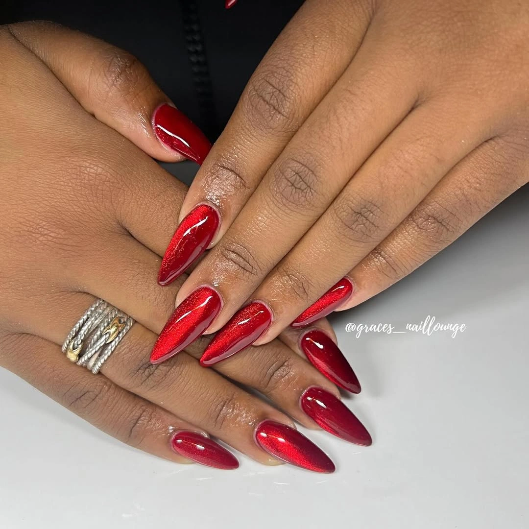 Crimson shimmer stiletto nails on dark skin
