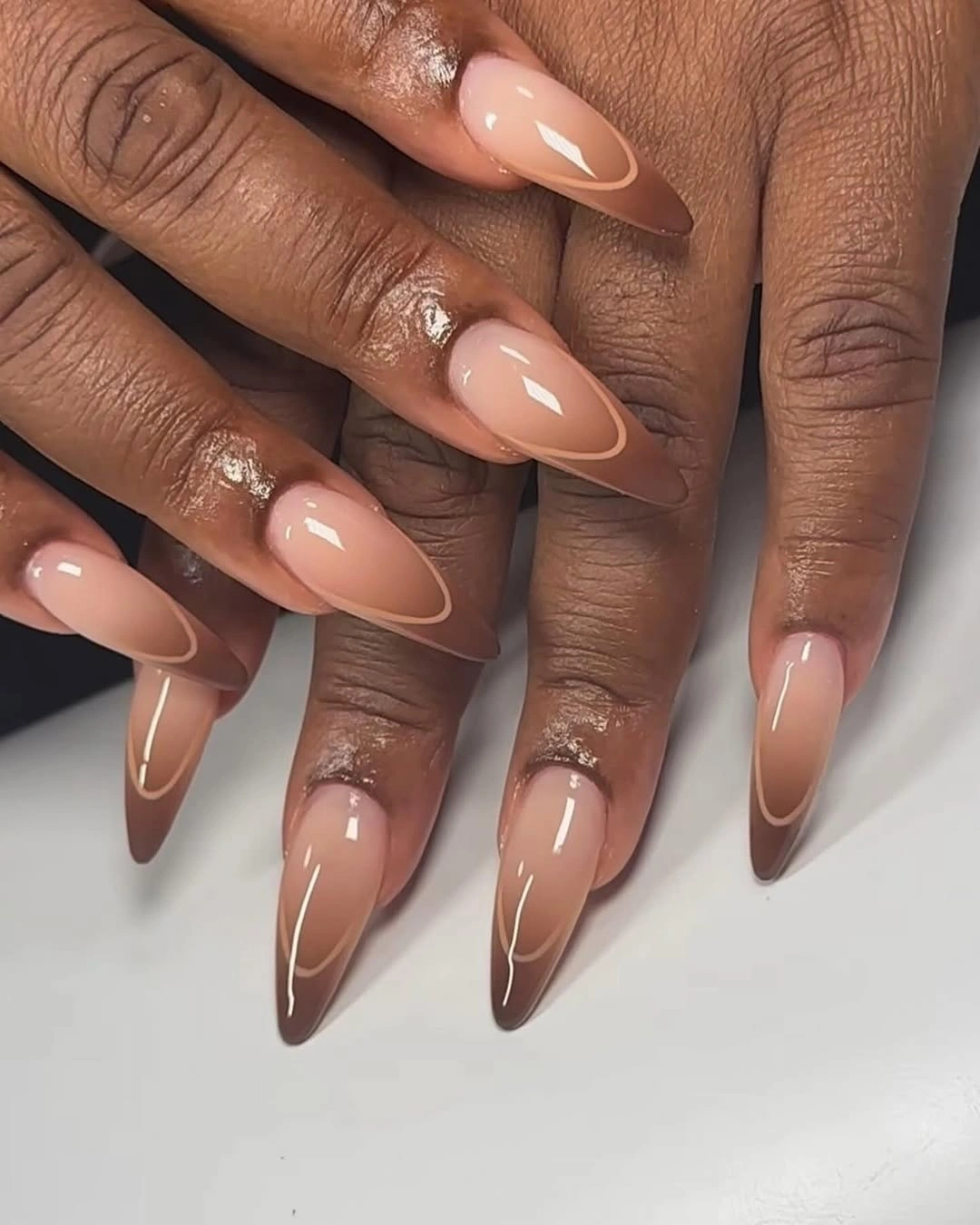 Nude brown ombre almond nails with fine outlines