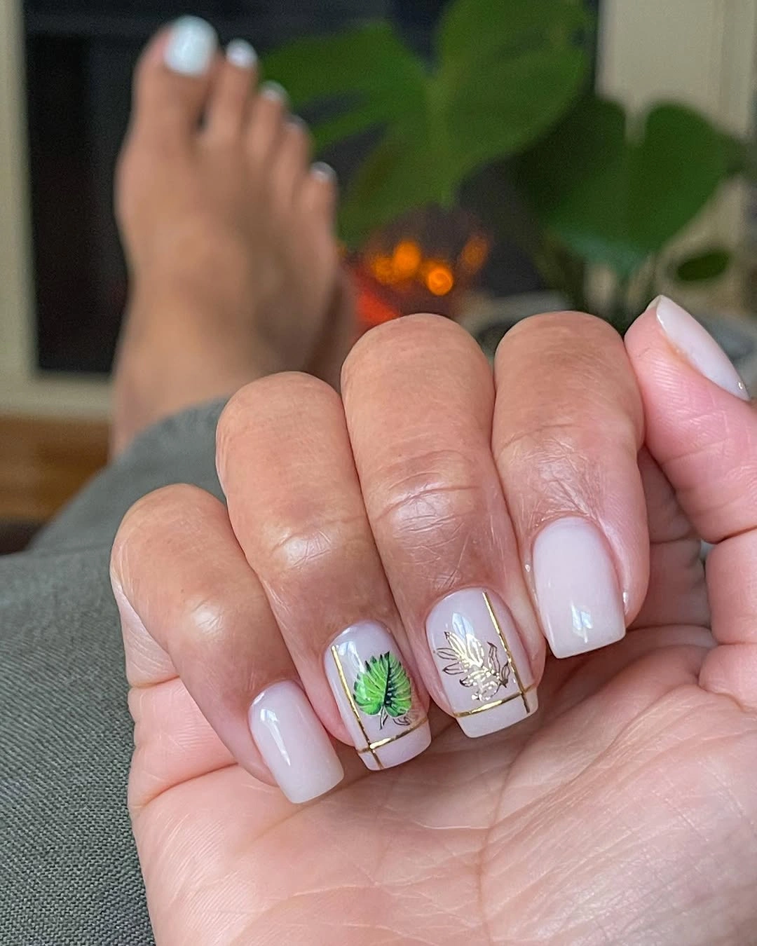 Milky nude square nails with green leaf accents