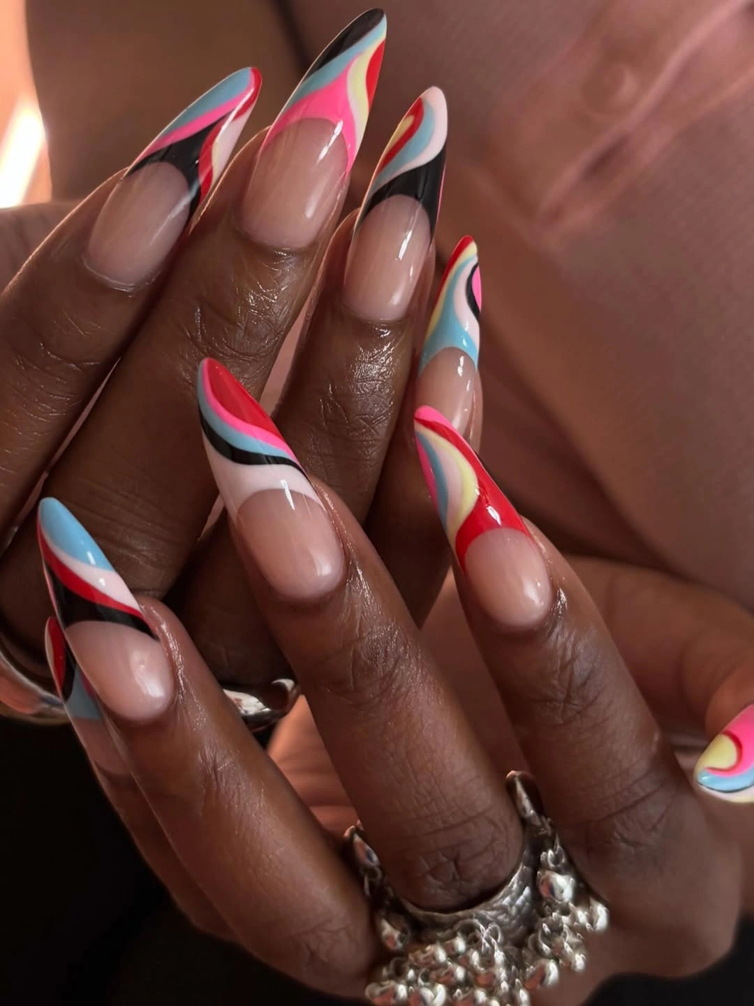 Nude almond nails with multicolor swirl tips
