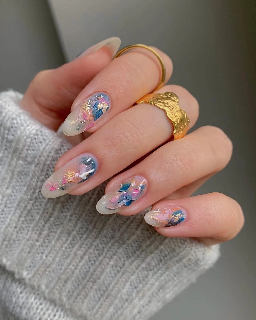 Medium almond sheer nails with scattered blue pink and lavender iridescent fragments