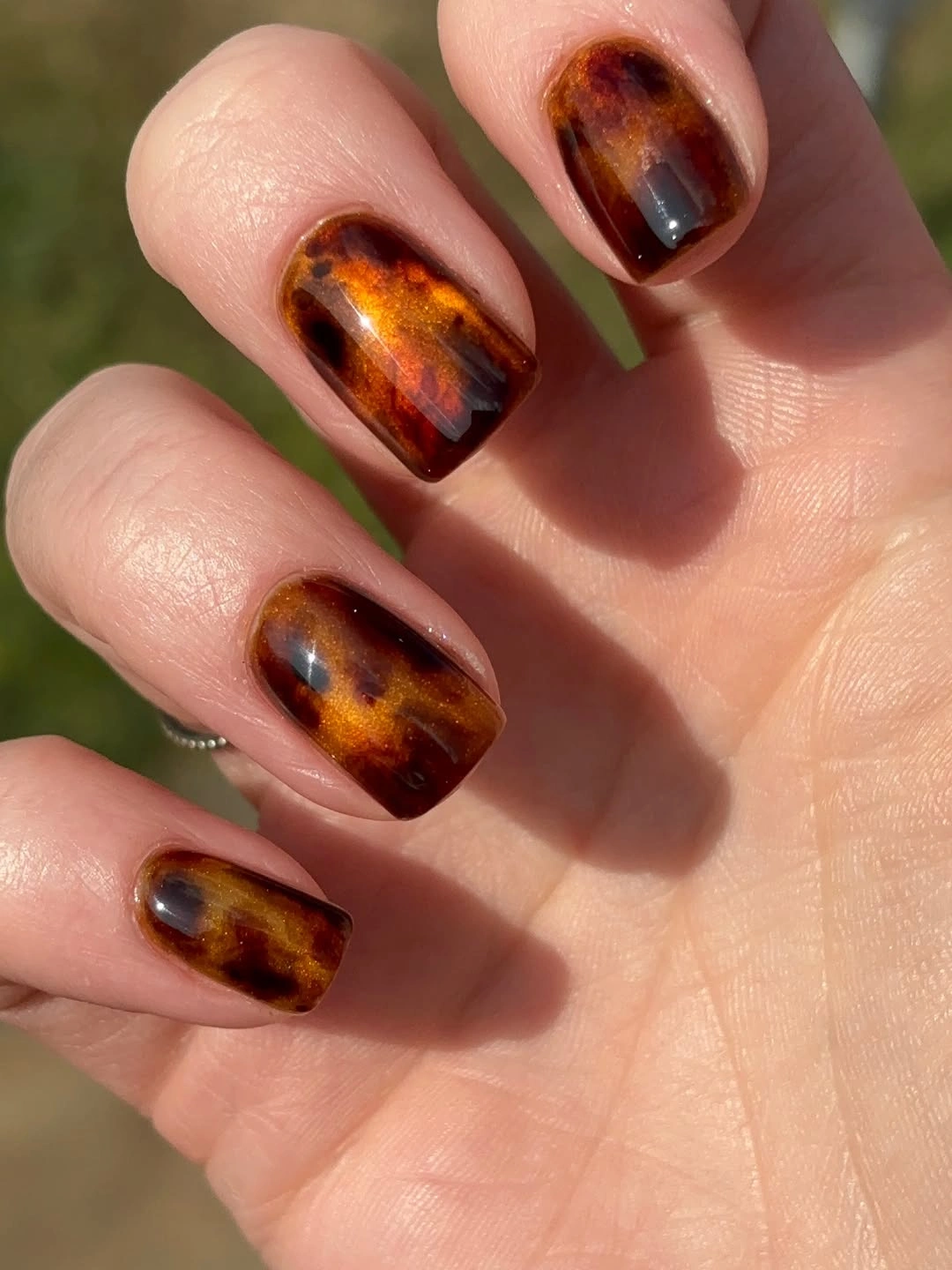 Short square nails with glossy amber brown and black tortoiseshell-style patches