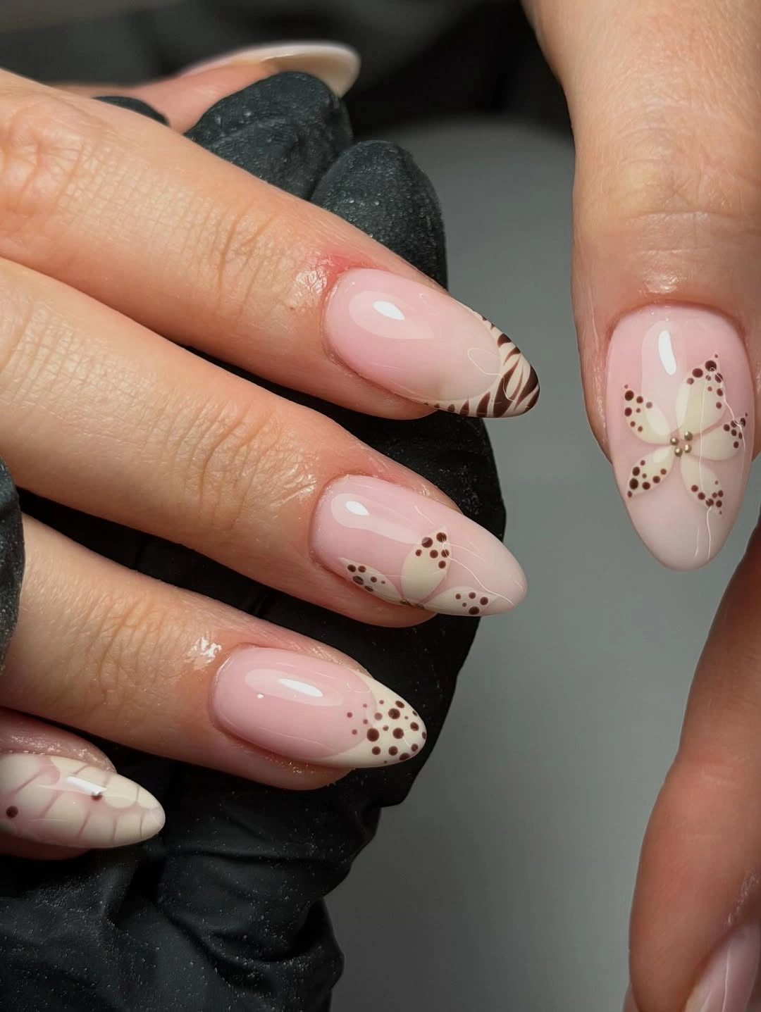 Long nude almond nails with fine brown outlined floral details