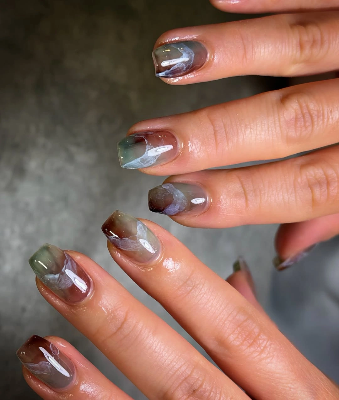 Medium translucent nails with smoky blended olive gray brown and muted red colors