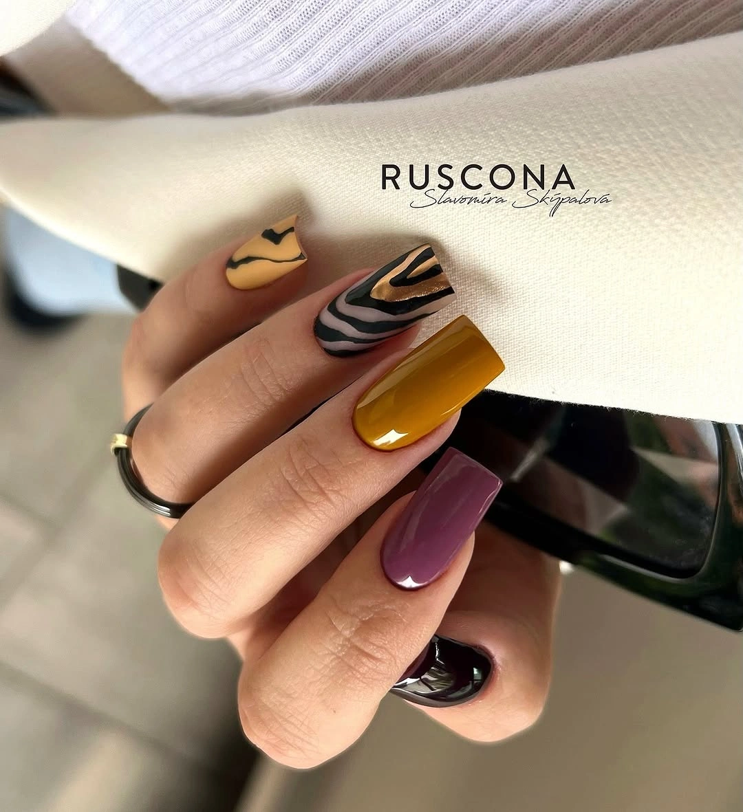 Mustard mauve and pale almond nails with black zebra stripe accents
