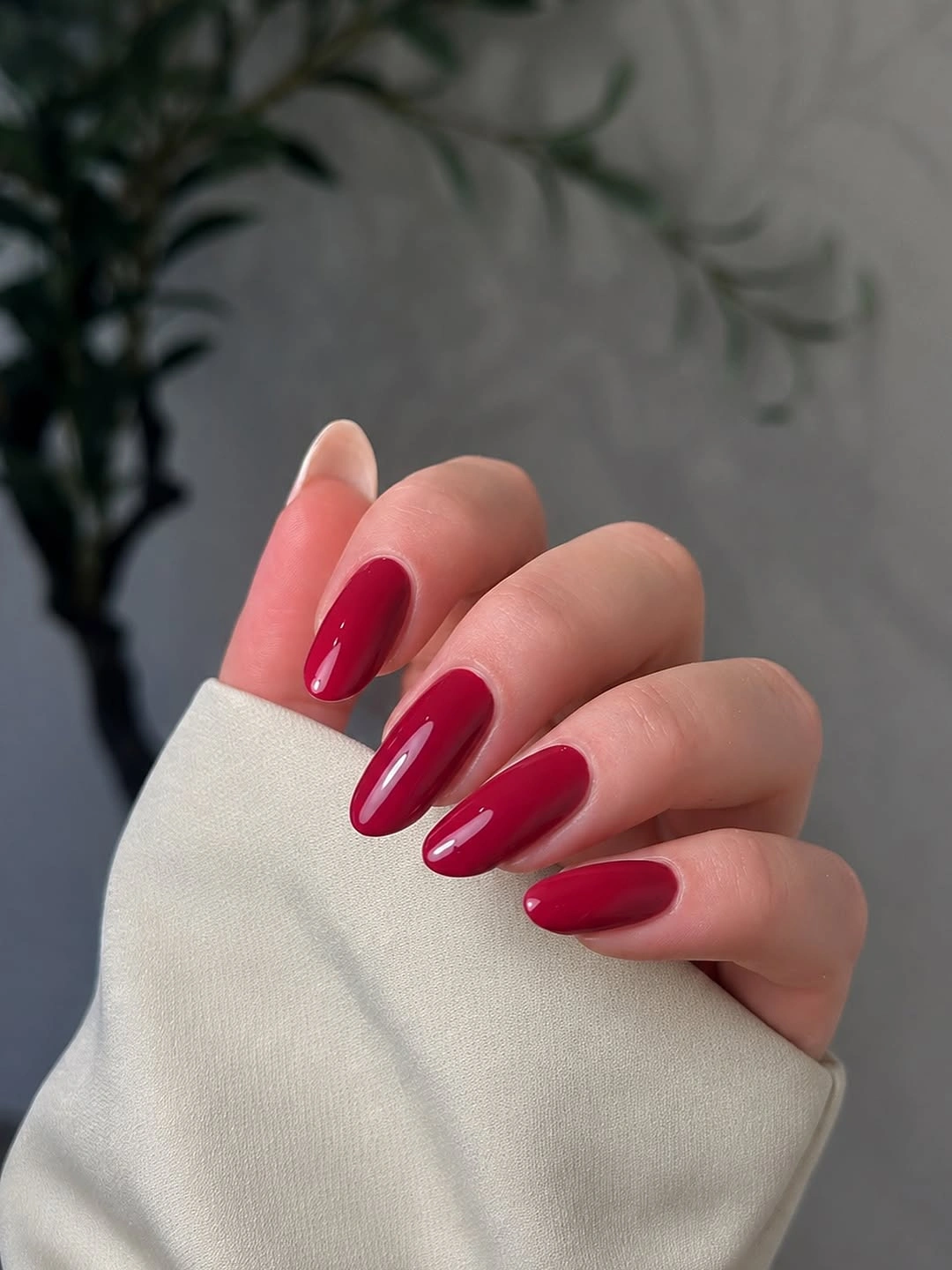 Long almond nails painted in a vivid glossy berry fuchsia color