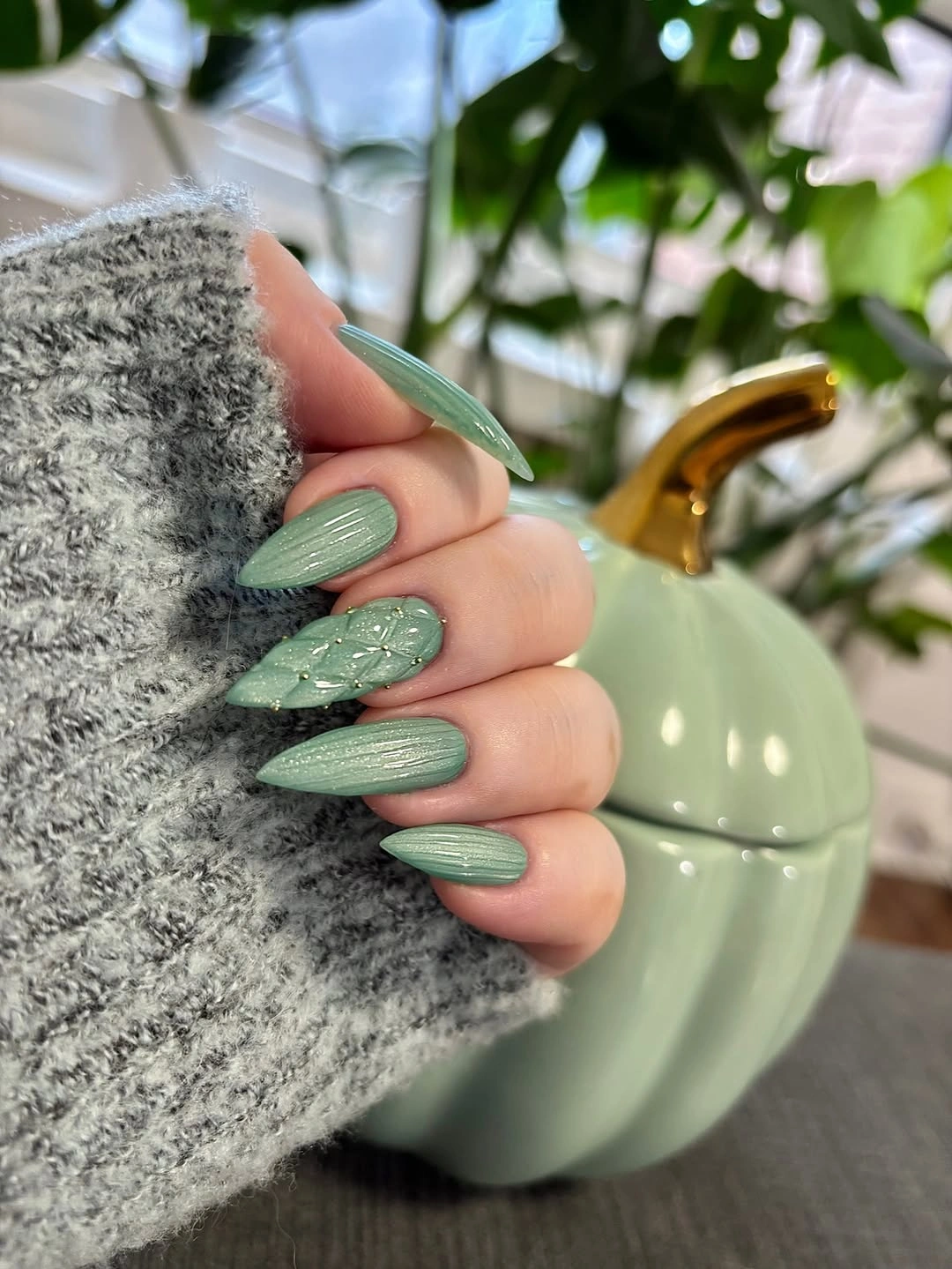 Long sage almond nails with ribbed texture and a leaf-like accent