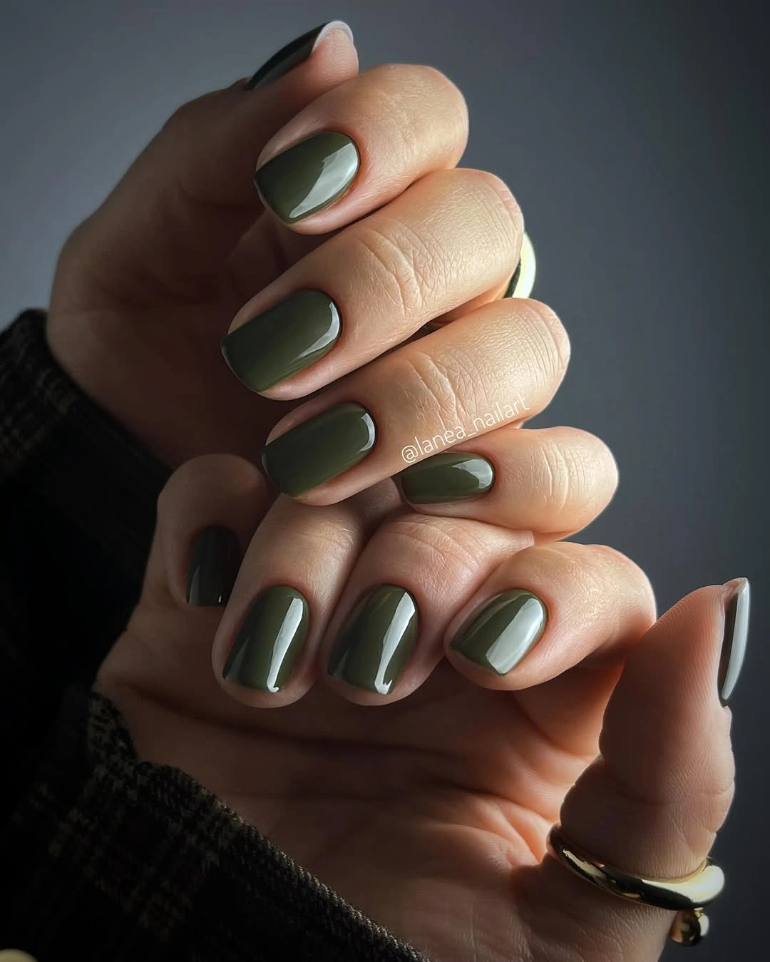 Short rounded olive green nails in one glossy solid color