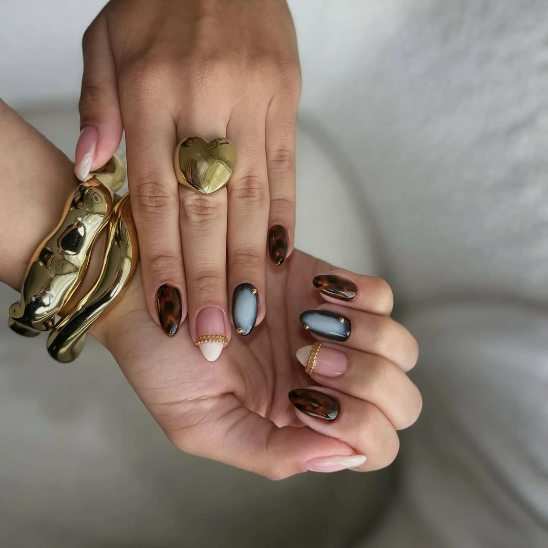 Brown gray-blue and nude almond nails with small gold heart detail