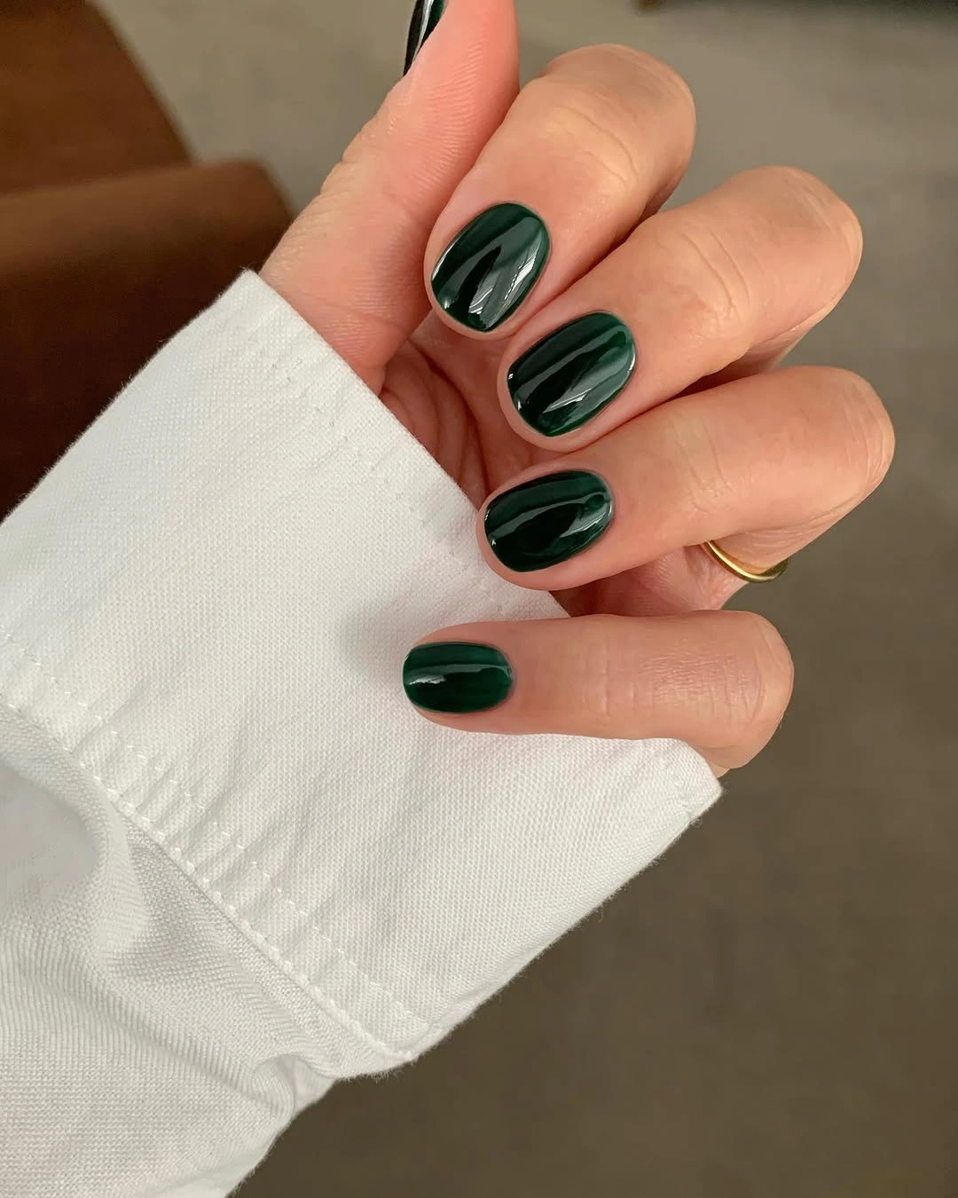 Short rounded glossy forest green manicure in one deep shade