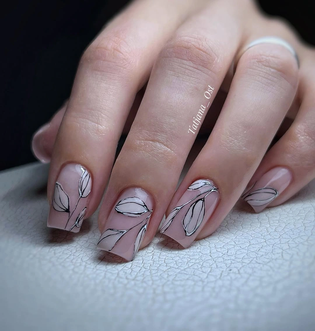 Sheer nude almond nails with fine black botanical line art