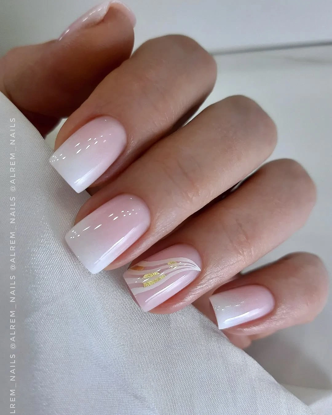 Milky square French nails with soft white tips and one gold leaf accent