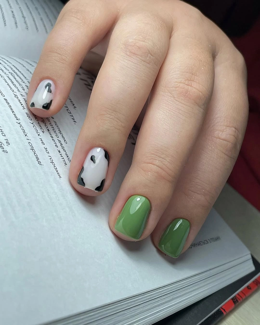 Short rounded white and green nails with crisp black-edged graphic color blocks