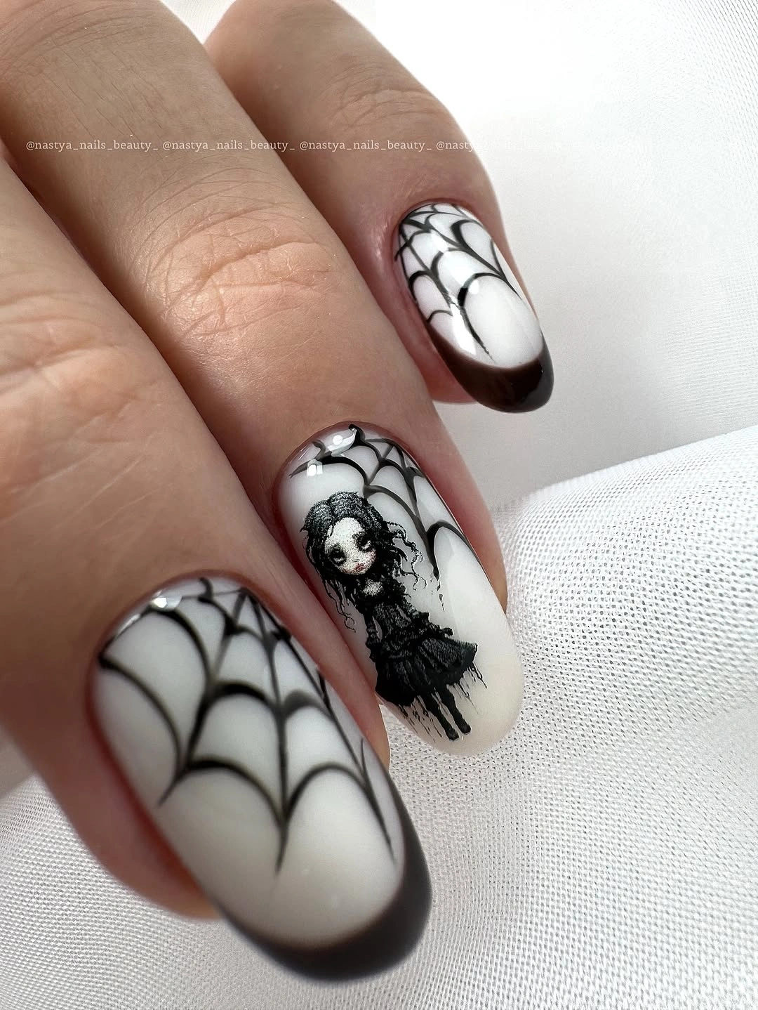 Black and white graphic nails with web-like lines and dark framed tips