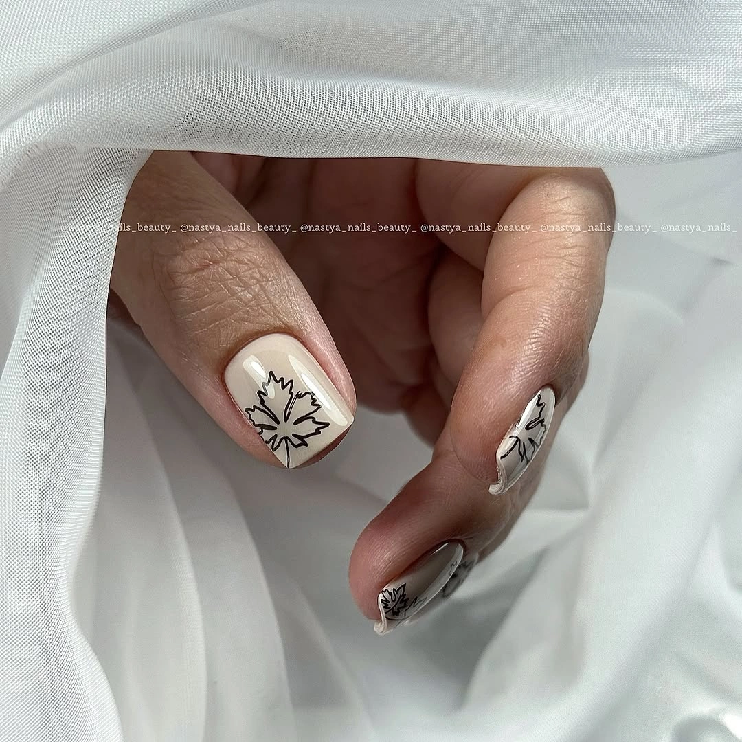 Long sheer nude nails with isolated black and white leaf outlines