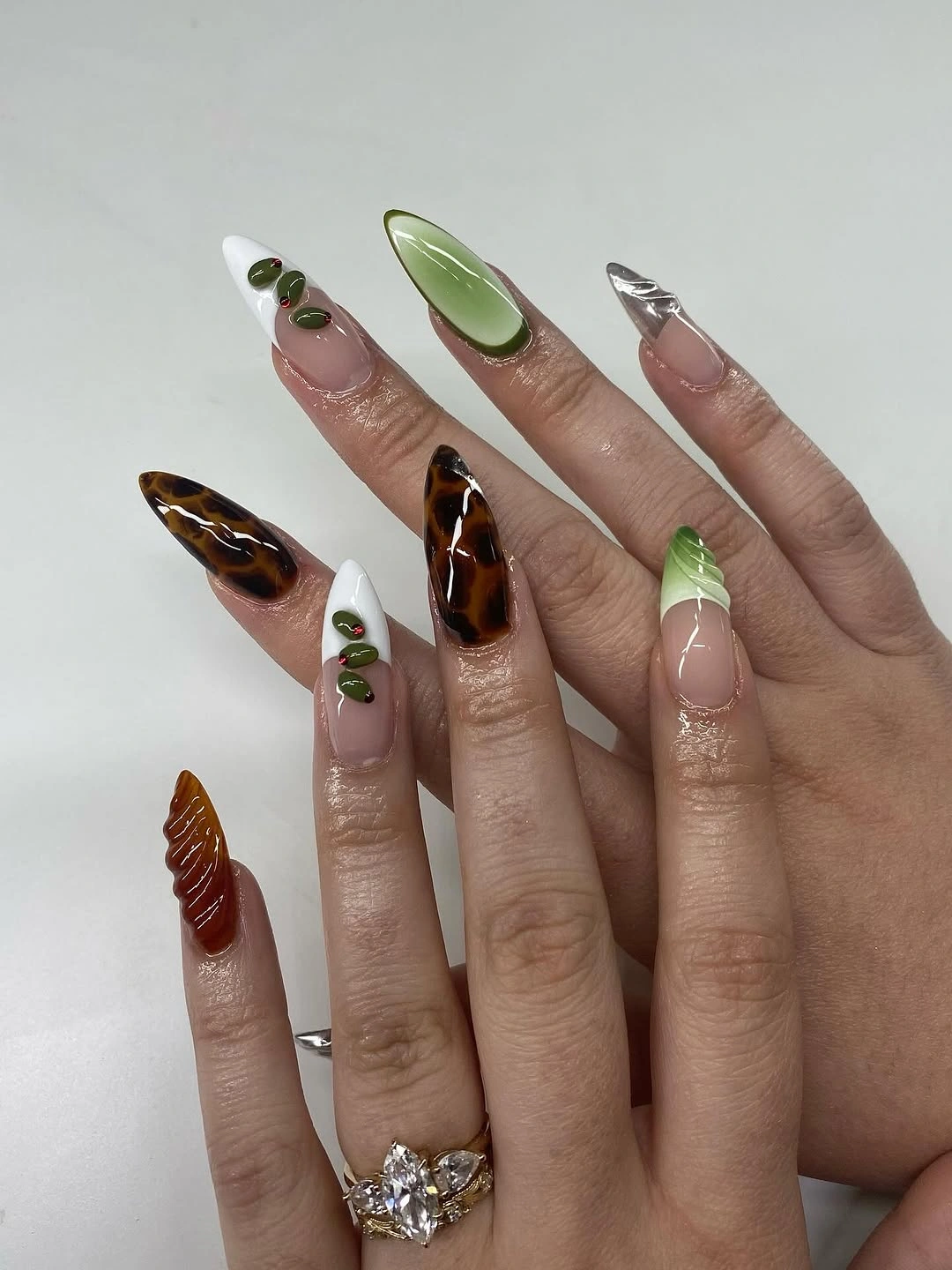 Long almond fall nails with translucent green brown white and silver accents