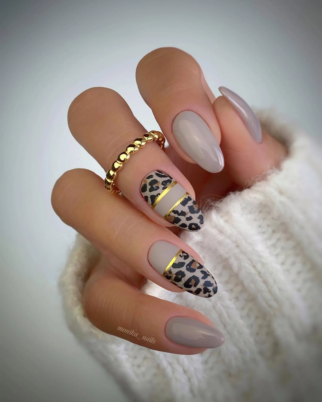 Medium almond nude nails with gold edged leopard-like accent panels