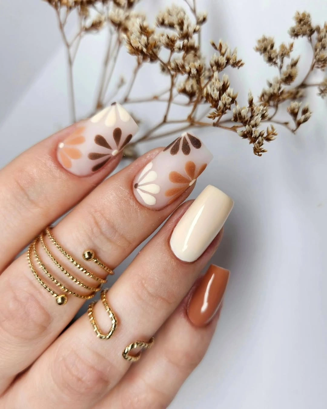 Medium square cream and brown nails with small two-tone floral accents