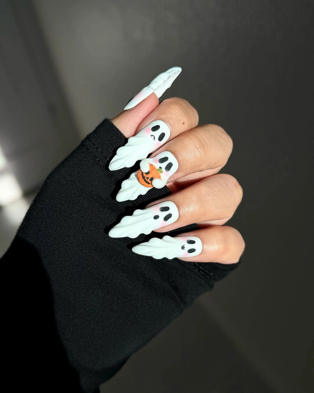 Very long stiletto white nails with ghost-like raised-looking black and white accents