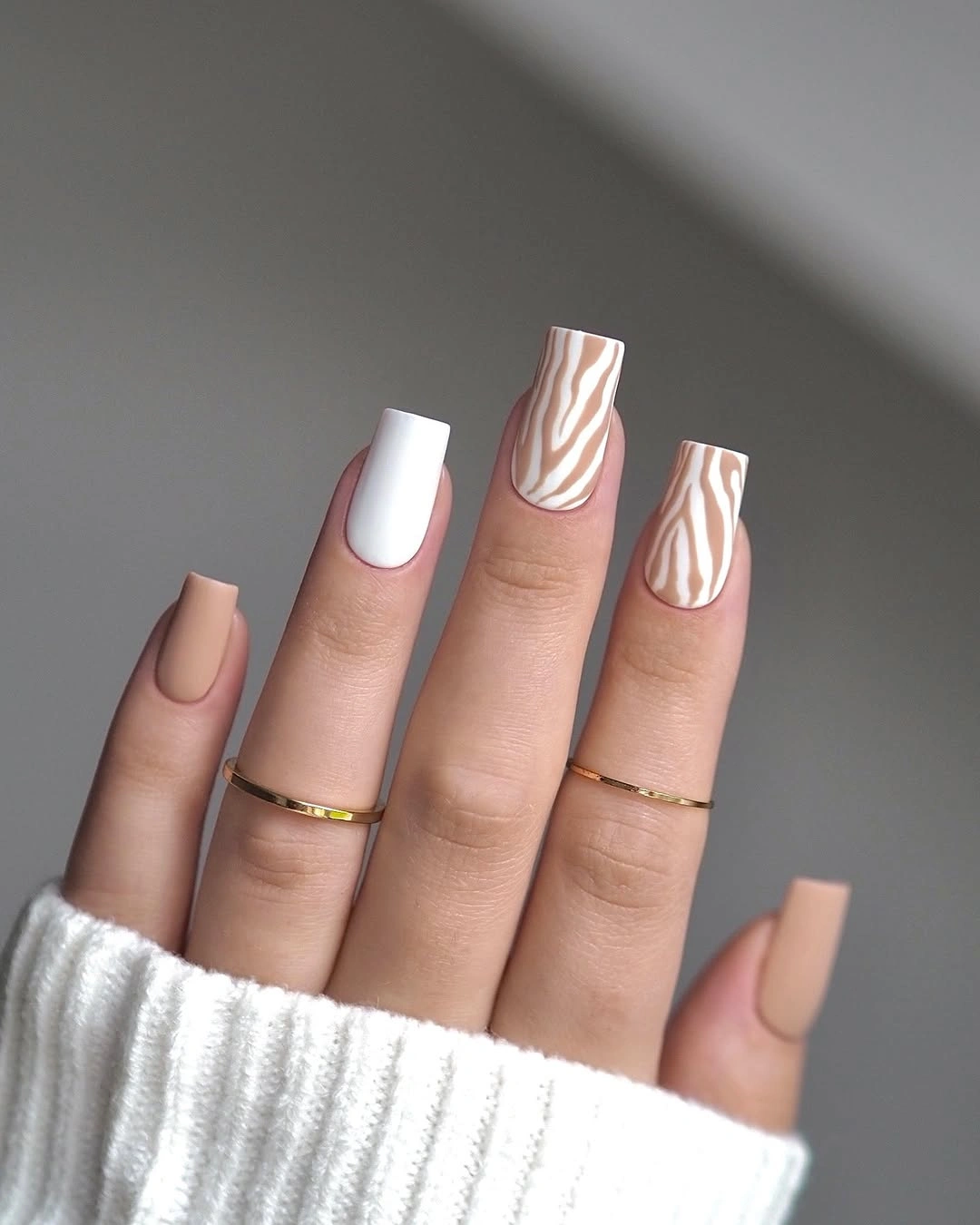 Medium square nude and white fall nails with flowing brown wave accents