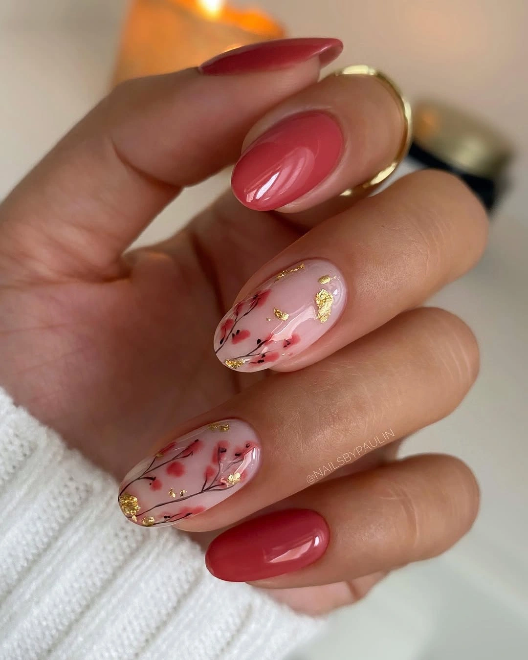 Medium almond red fall nails with translucent floral and gold accents