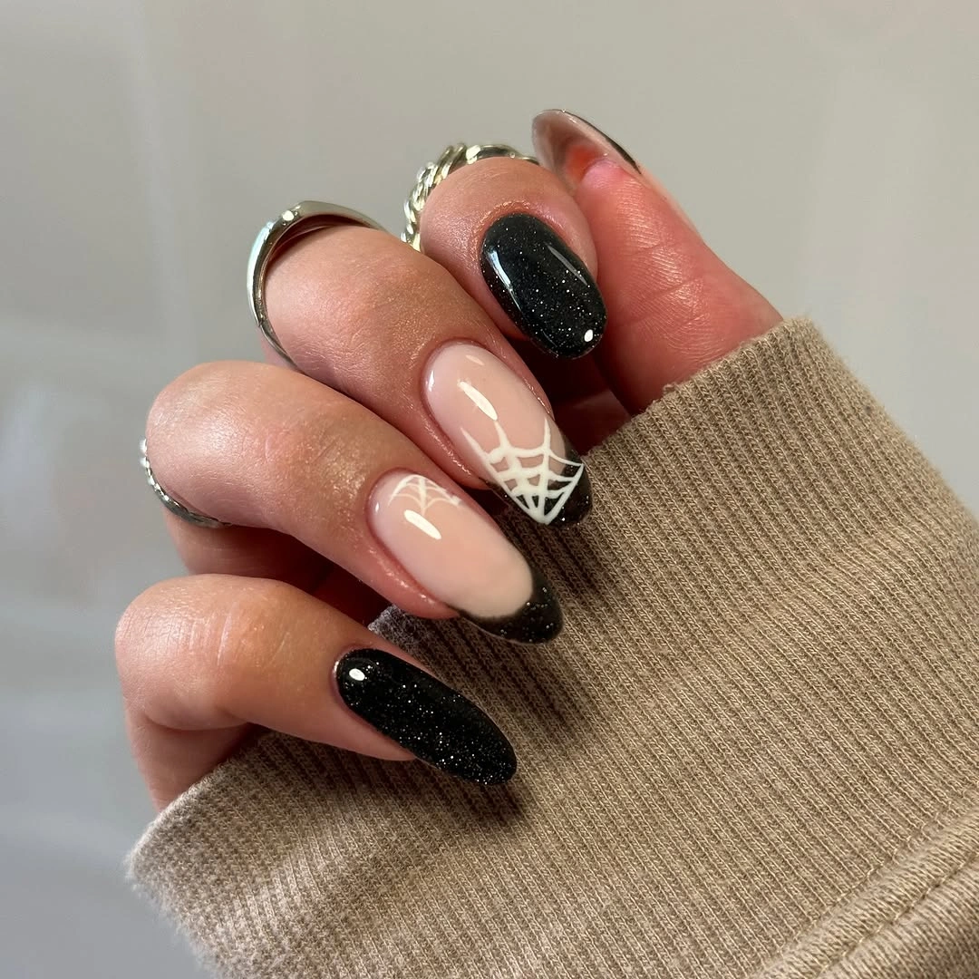 Medium almond nude and black nails with pale leaf accent