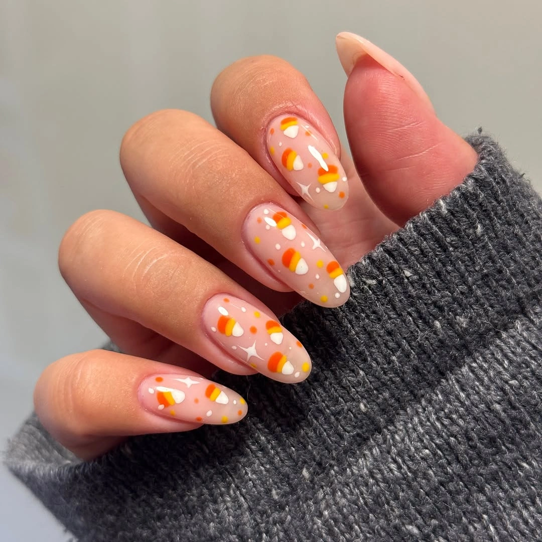 Medium almond nude nails with orange yellow and white accents