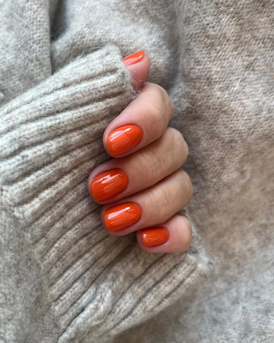 Short rounded nails in glossy pumpkin orange