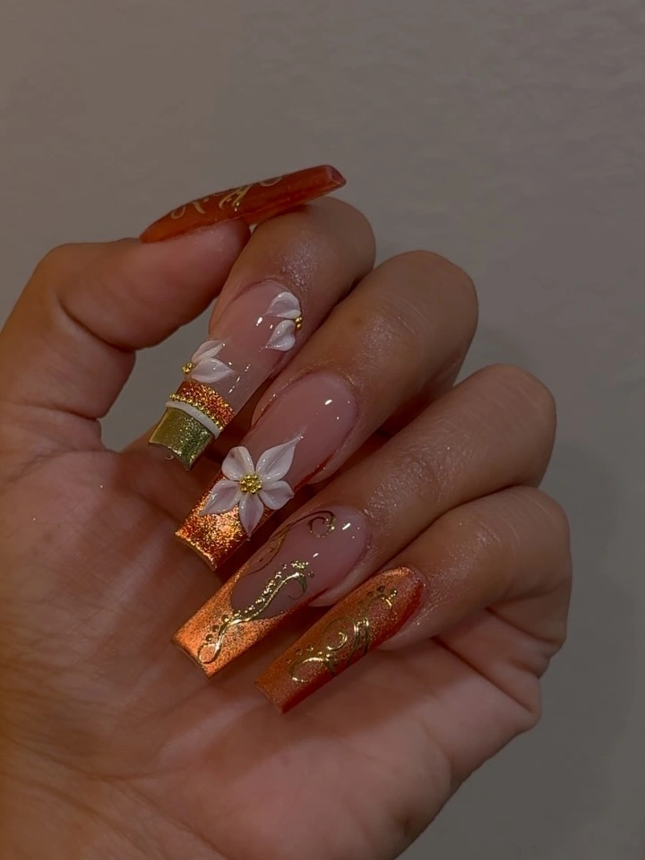 Long pointed nude nails with warm borders and white flower