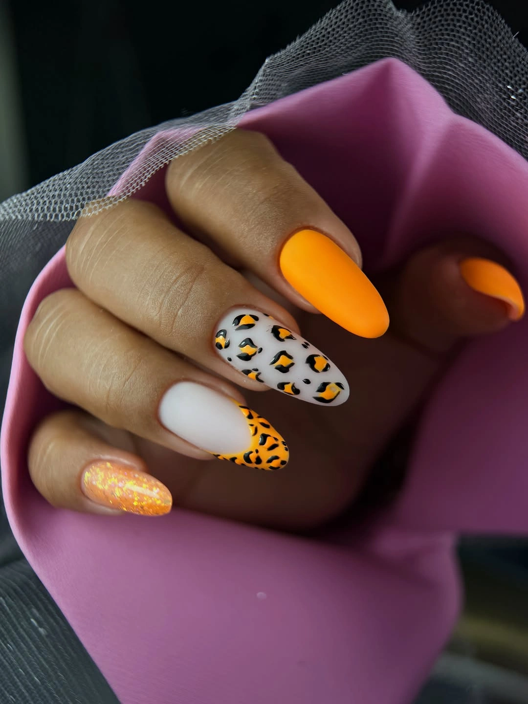 Medium almond white orange nails with one spotted accent