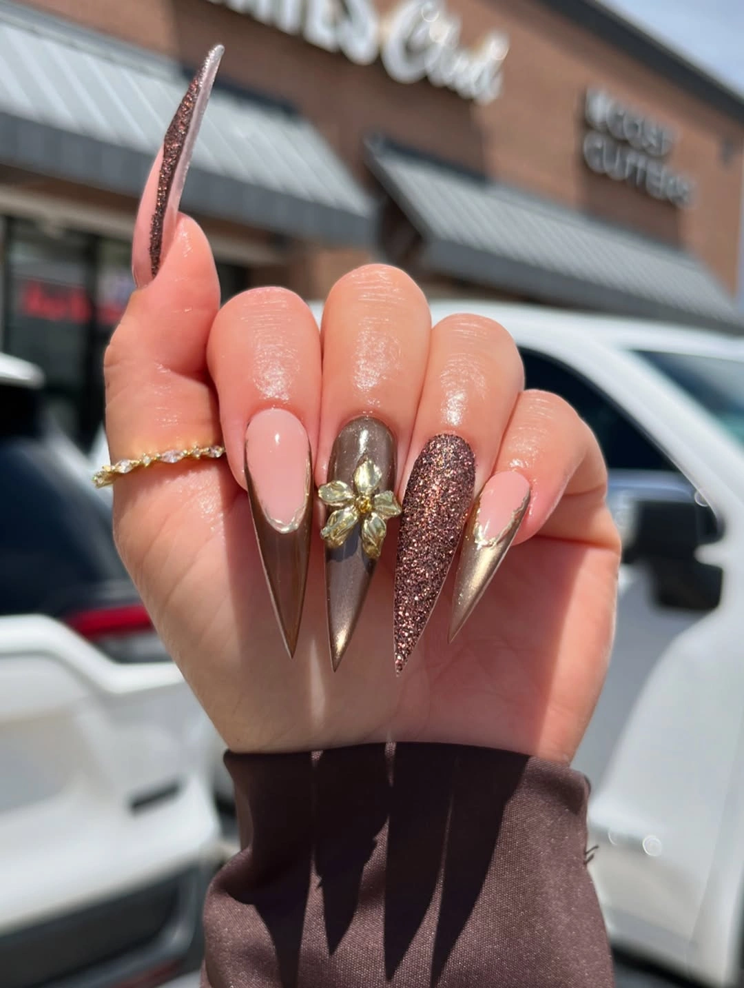 Long stiletto nude nails with rose gold and gold accents