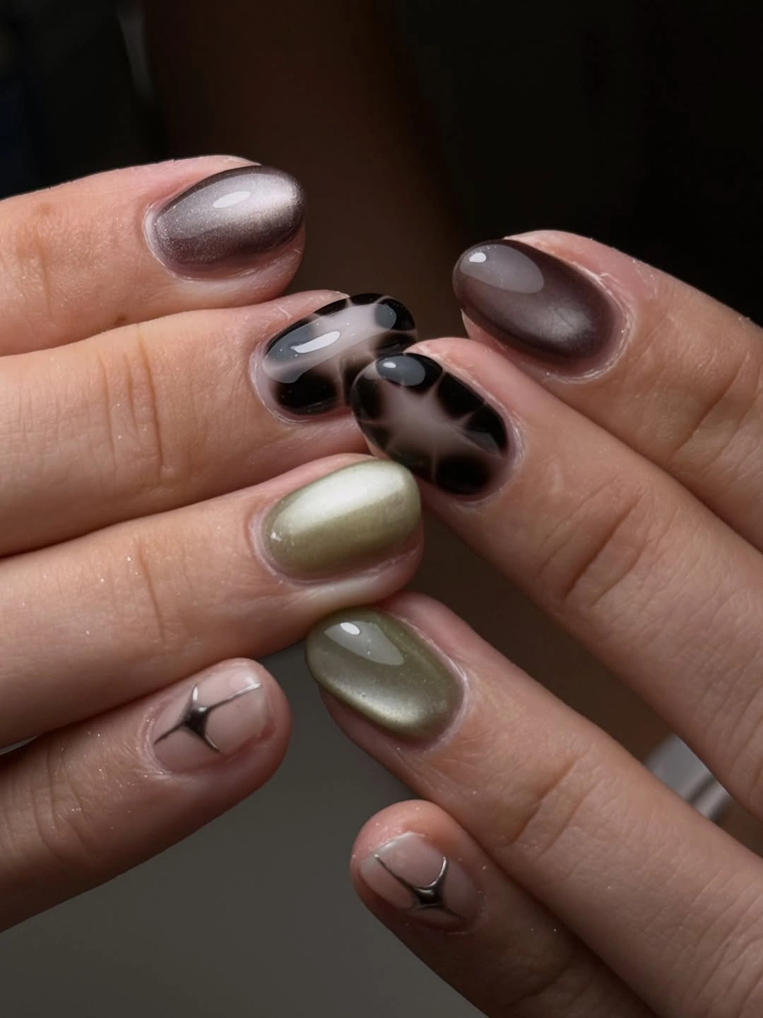Short rounded taupe olive nails with dark abstract spots