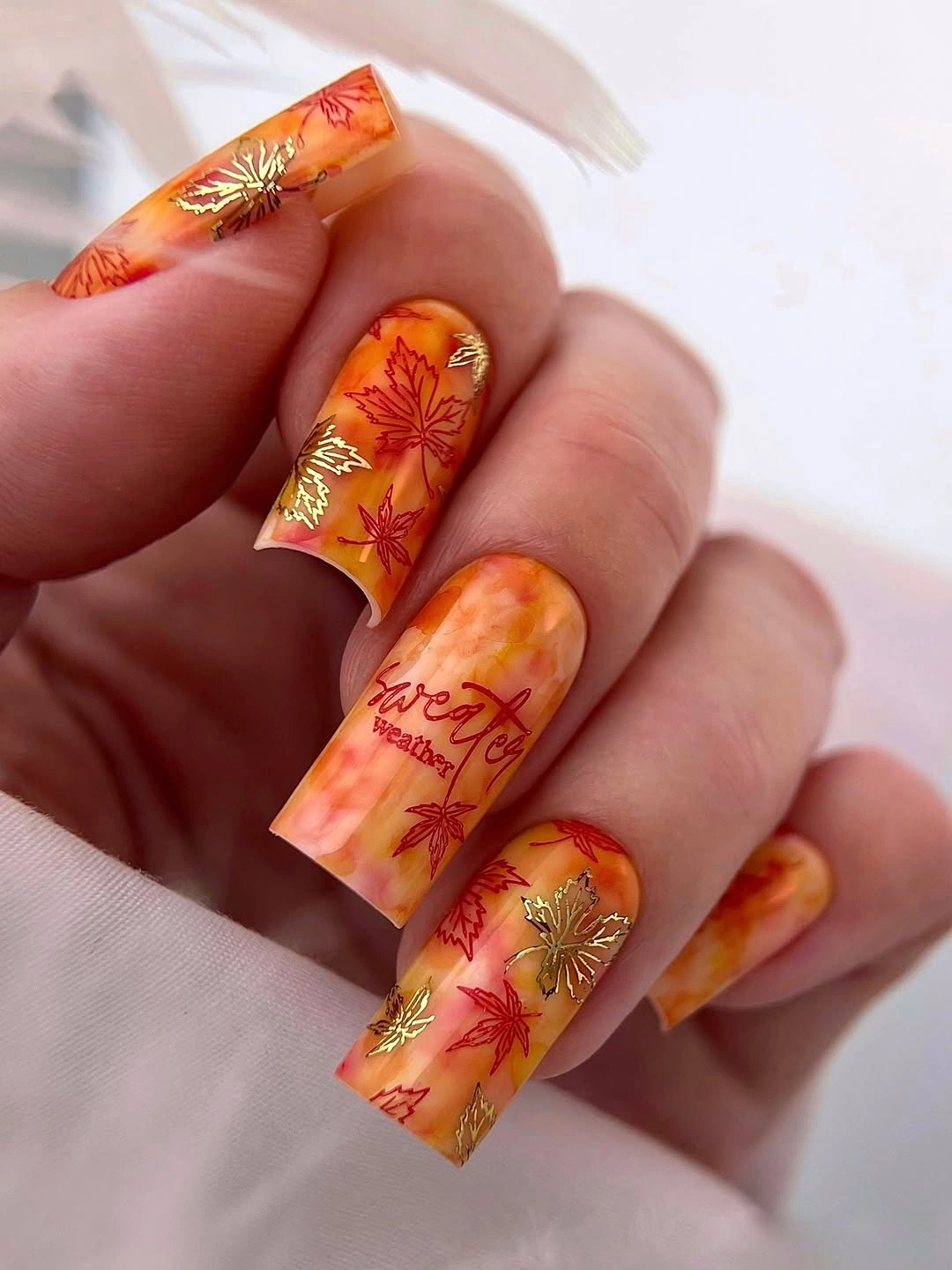 Long square orange nails with layered autumn illustrations