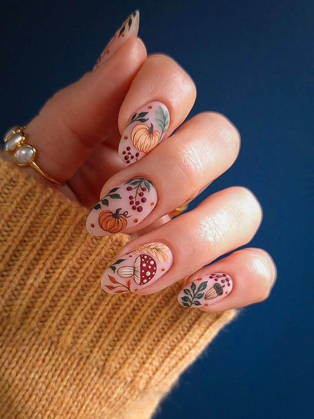 Short nude nails with tiny pumpkins, berries, and leafy sprigs