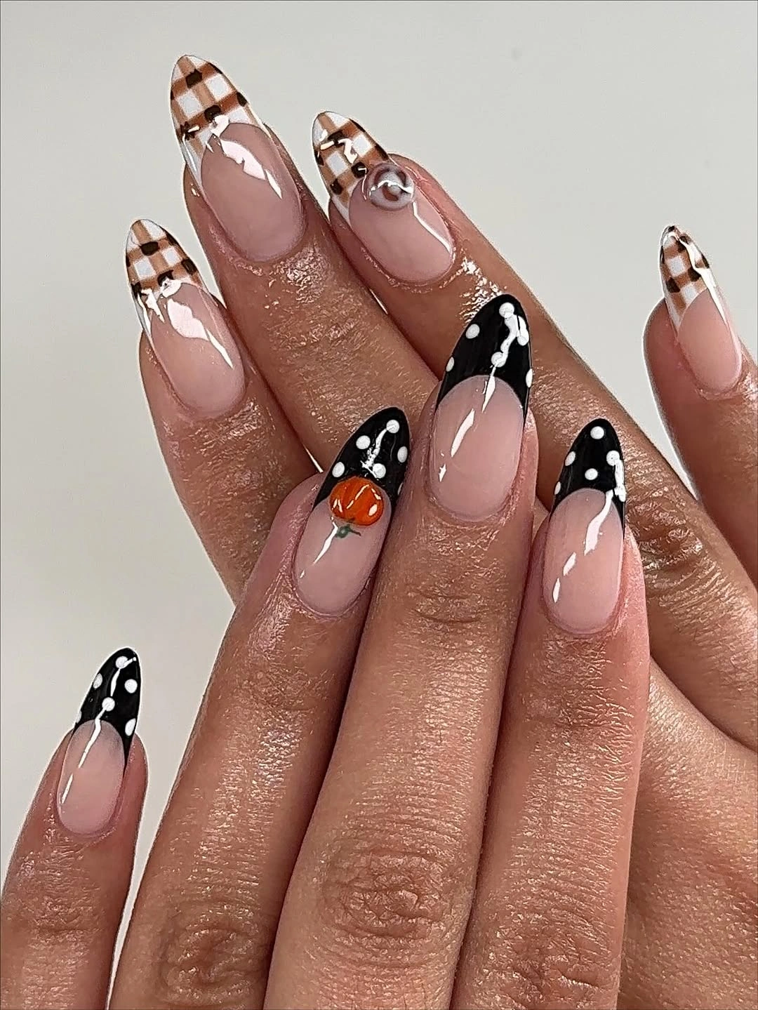 Nude almond nails with brown plaid tips and tiny pumpkins