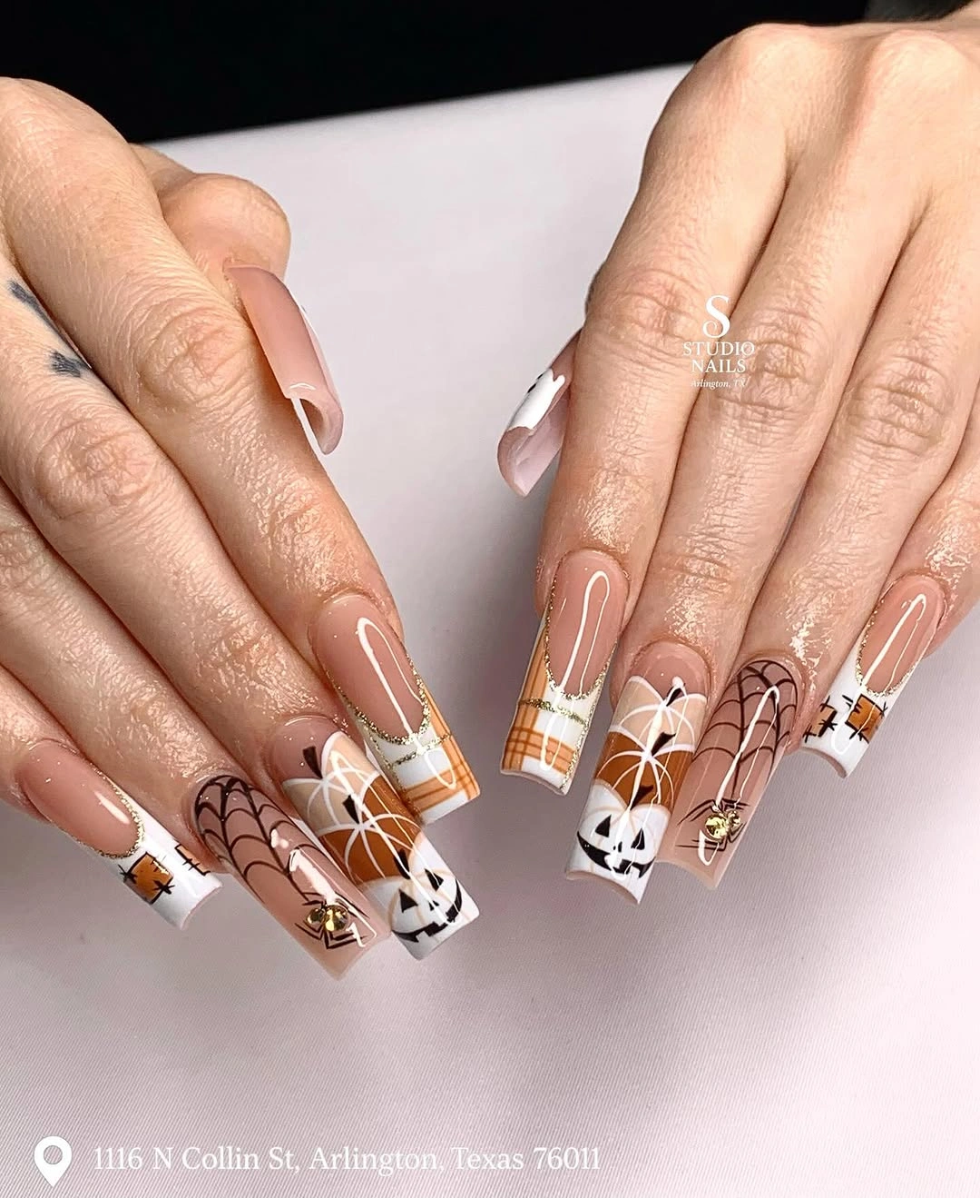 Long coffin nails with spiderwebs, pumpkins, and graphic tips