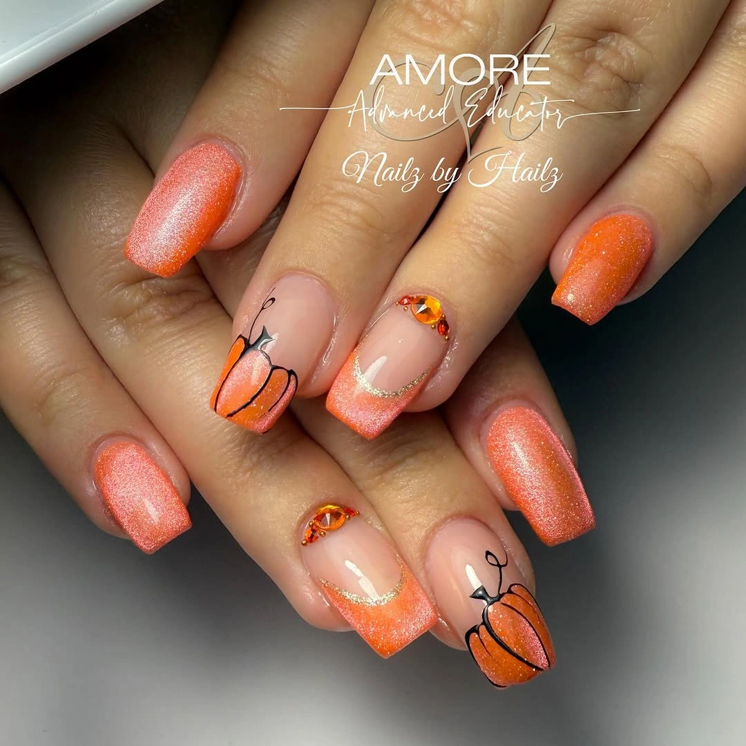 Short coral shimmer nails with nude pumpkin outlines