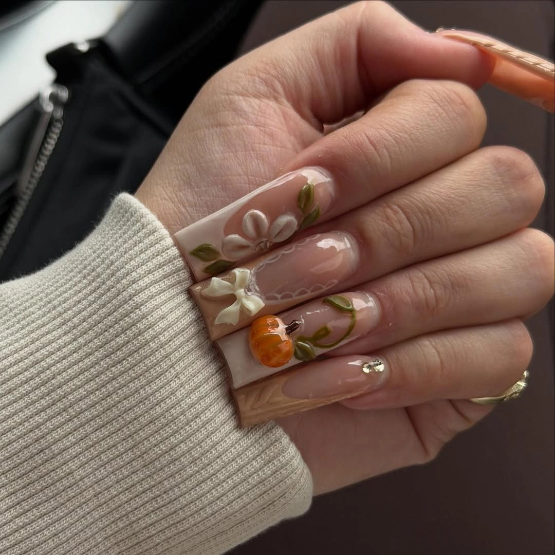 Long nude square nails with botanical flowers, leaves, and pumpkin