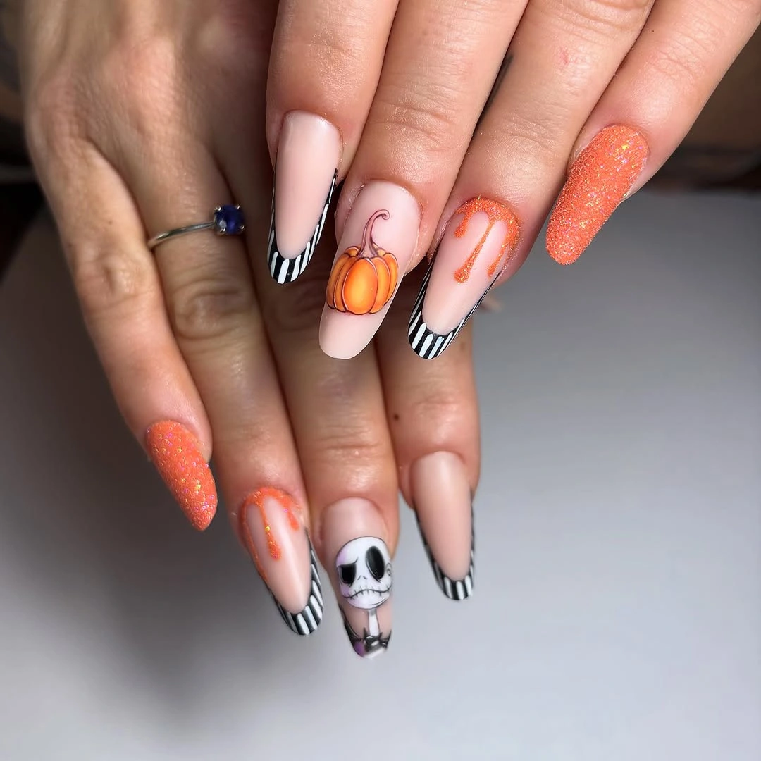 Pale almond nails with striped tips, pumpkins, and ghostly accents
